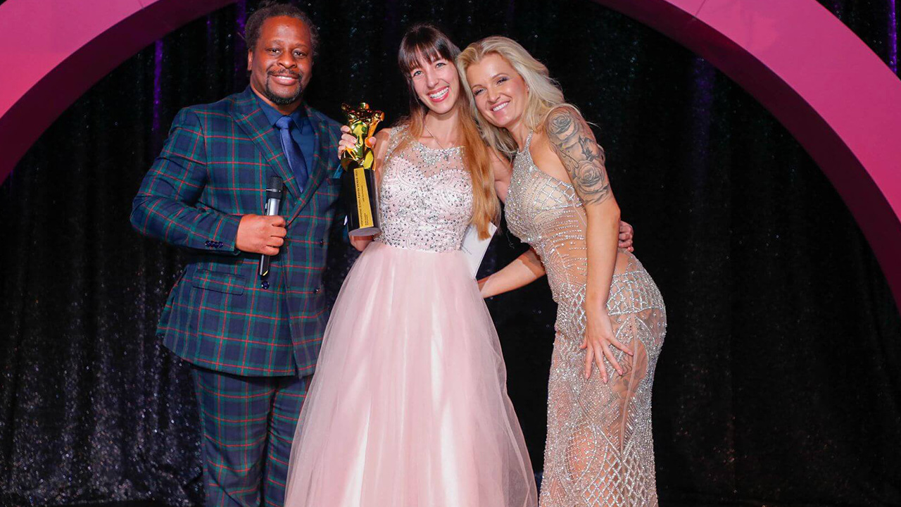 Layla von Hohensee mit Venus Award 2023 Trophäe zwischen Moderatoren Mola Adebisi und RoxxyX auf der Bühne im Wintergarten Varieté Berlin