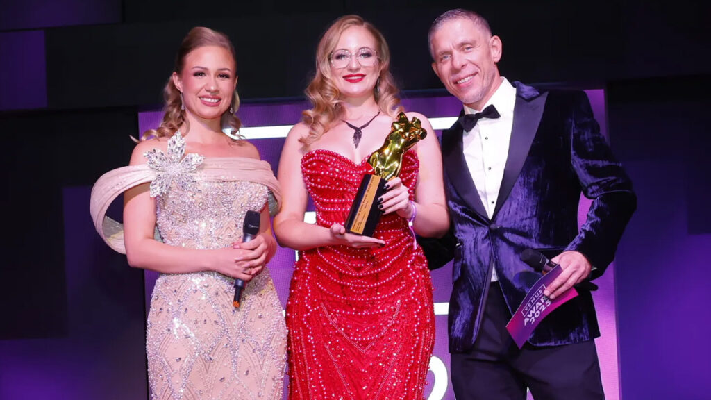 Mika Nox mit Venus Award 2025 Trophäe auf der Bühne zwischen Moderatorin Gabi Gold und Moderator Mick Blue im Wintergarten Varieté Berlin