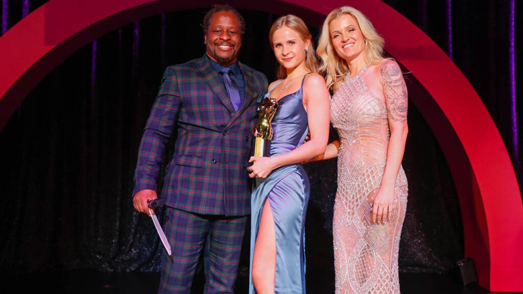 Sweetgini mit Venus Award 2023 Trophäe zwischen Moderatoren Mola Adebisi und RoxxyX auf der Bühne im Wintergarten Varieté Berlin