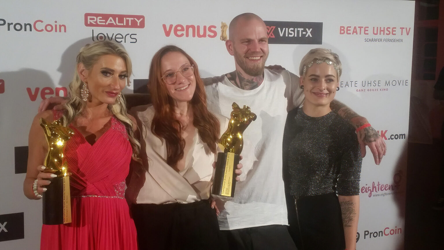 Vika Viktoria und Pornagent Team mit Venus Award 2018 Trophäen vor der Medienwand in Berlin